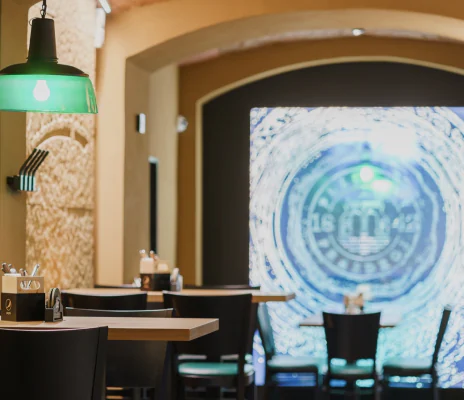 Interiér restaurace Plzeňka Carlsbad se zelenou lampou